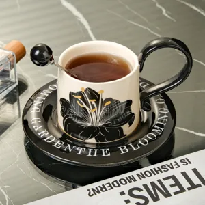 Vintage keramische koffiekop en schotel set, elegant zwart bloemenpatroon voor thee.
