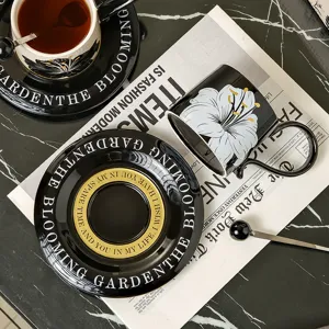 Gedetailleerd shot van retro zwart-witte keramische koffiekop en schotel set met gouden opdruk.