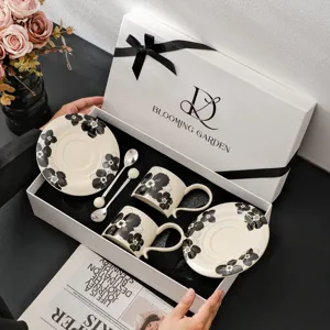 Retro keramische koffiekop en schotel set met geschenkdoos, elegant zwart bloemendesign.