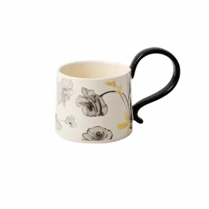 Keramische mok detail met prachtig bloemenpatroon en uniek zwart modern handvat.