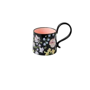 Elegante zwarte keramieken koffiemok met bloemenpatroon en roze binnenkant voor thuis.