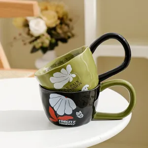 Detailed shot of stacked ceramic coffee mugs with artistic unique shape and stylish English quotes.