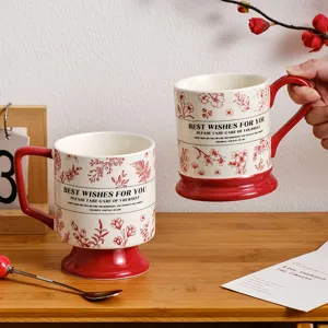 Retro ceramic coffee mug featuring elegant red floral pattern and stable pedestal base.