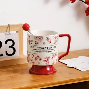Ceramic coffee mug with creative red base, elegant floral pattern and spoon detail.