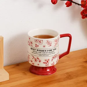 Close-up detail view of a retro ceramic coffee mug featuring red floral print and handle.