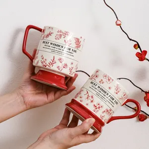 Creative ceramic coffee mug with retro red floral design and motivational text handles.