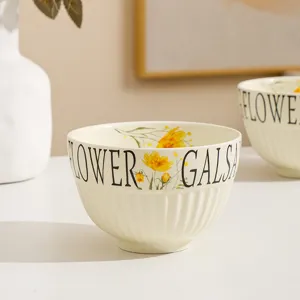 Cream style ceramic rice bowl detailed shot, featuring yellow floral print and lettering.