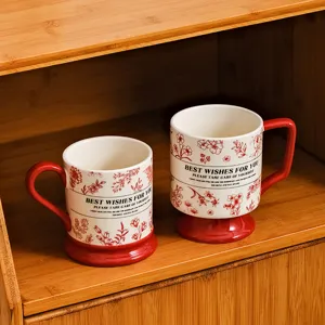 Ceramic mug set with red base and vintage floral pattern, retro coffee cup detail view.