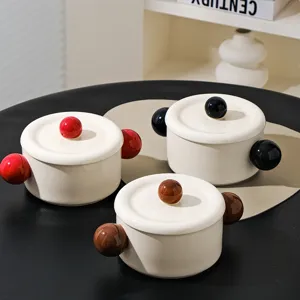 Detail view of ceramic instant noodle bowls with lids and colorful ball handles for kitchen.