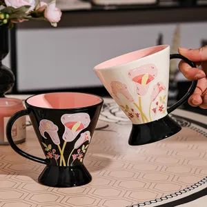 Tazza da caffè in ceramica con base alta e motivo floreale, elegante per casa e ufficio.