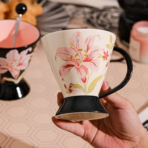 Dettaglio della tazza in ceramica con giglio in rilievo, elegante base alta con manico nero.