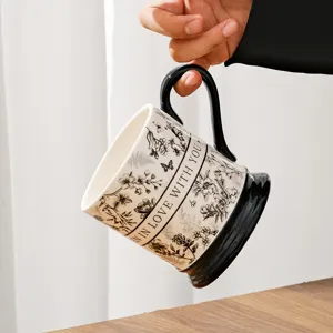 Close-up of vintage ceramic coffee mug with floral pattern, black handle and base detail.