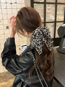 Coletero chic con estampado de leopardo y cinta larga con lazo, accesorio de moda para mujer.
