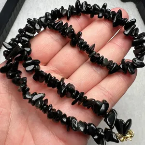 Collana con pietre irregolari in ossidiana nera naturale e chiusura dorata gioiello.