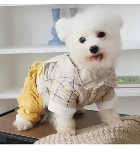 Detailed shot of a cute dog wearing a warm plaid four-leg shirt pet winter coat with cute style.