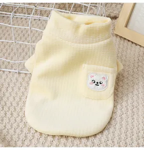 Close-up of cute yellow dog fleece vest detail, warm high collar and sweet bear pocket design.