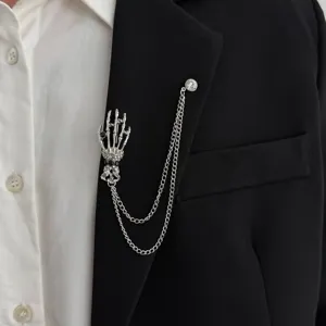 Men's gothic skeleton hand brooch pin with tassel chain, stylish suit lapel jewelry accessory.