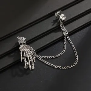 Detailed closeup view of the rhinestone skeleton hand brooch with tassel chain for men.