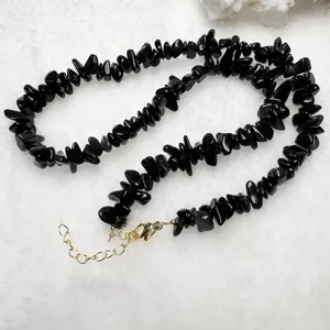 Collana di pietre grezze in ossidiana nera con chiusura dorata e catenella di estensione.