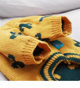 Detail view of yellow and green knitted pet dog sweater collar and cuffs winter warm apparel.