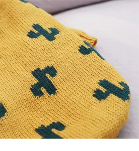 Close-up detail view of the yellow knit pet sweater featuring a cute green cactus pattern.