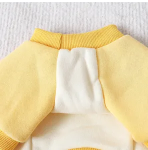 Close-up detail of soft yellow and white colorblock pet fleece sweater for winter warmth.