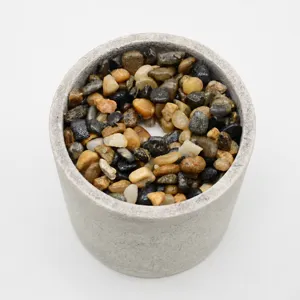 Gray round flower pot filled with colorful decorative stones for artificial plants bonsai.