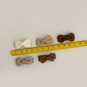Vue détaillée de 5 pinces à cheveux noeud pour animaux avec règle de mesure de taille.