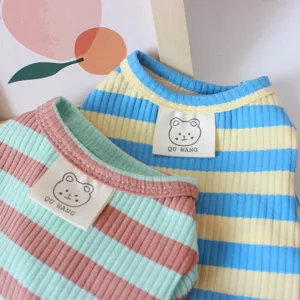 Primer plano de los detalles de ropa a rayas para mascotas con tela suave y etiqueta.