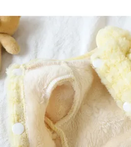 Detailed close-up of warm pet fleece winter clothes, soft fluffy inner lining, secure snap buttons.
