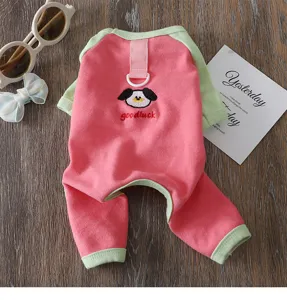 Close-up detail of cute pink and green color-block pet jumpsuit with puppy embroidery.