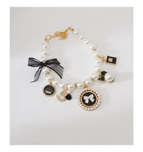 Elegant pet pearl necklace with black bow and vintage charms for dogs cats stylish.