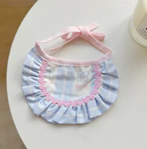 Detailed view of cute pet bib with blue stripes, pink bows, and delicate lace trim.