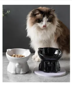 Gros plan de gamelles pour chats en céramique sur pied noir et blanc avec scène d'animal.