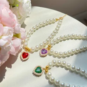 Pet pearl necklace closeup with colorful heart pendant, cute cat decoration accessory detail.