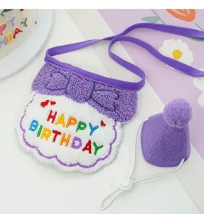 Close-up detail of cute pet birthday bib and cone hat set in purple and white plush.
