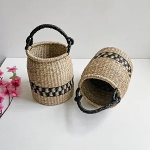 Handmade woven seagrass storage basket with black handle and geometric pattern for home decor.