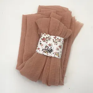 Detail shot of solid color natural pleated cotton linen scarf with raw fringe and bubble texture.