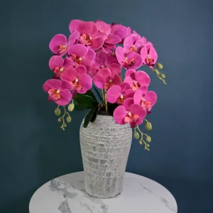 Artificial Phalaenopsis orchid potted plant in grey textured vase for home decor and wedding party.