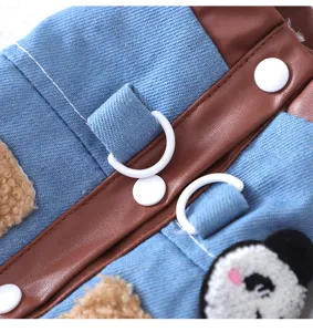 Close-up detail of pet denim clothing with brown faux leather trim and cute panda patch.