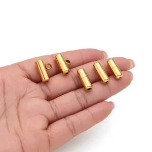 Gros plan de fermoirs à vis cylindriques en acier inoxydable doré pour bijoux DIY.
