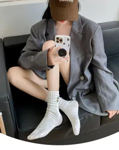 White ribbed mid-calf socks featuring delicate embroidered detail, street style fashion.