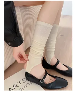 Beige stirrup leg warmers women knit long socks paired with black flat shoes daily casual wear.