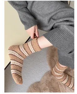 Vue détaillée de chaussettes duveteuses à rayures brunes, polaire corail douce pour l'hiver.