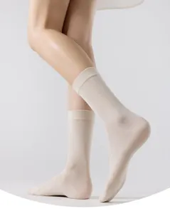 Gros plan détaillé montrant des chaussettes unies mi-mollet pour femmes sur jambe.
