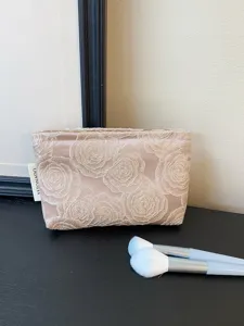Satin cosmetic bag featuring delicate 3D rose embroidery, perfect for travel and daily storage.