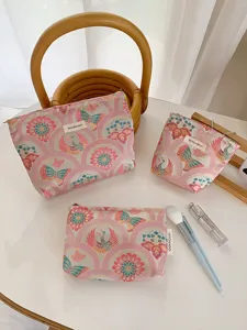 Detailansicht des rosa Brokat Kosmetiktaschen Sets mit Blumen und Schmetterlingsmustern.