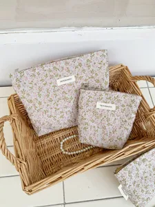 Detail view of French floral embroidered canvas cosmetic storage bag in woven basket setup.