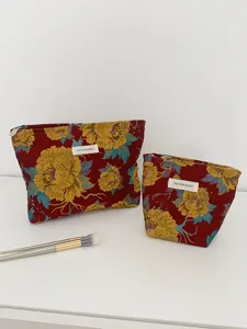 Detail view of retro floral cosmetic makeup bags with woven fabric texture and zipper closure.