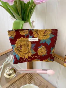Vintage floral jacquard cosmetic bag detail view, elegant travel storage pouch texture.